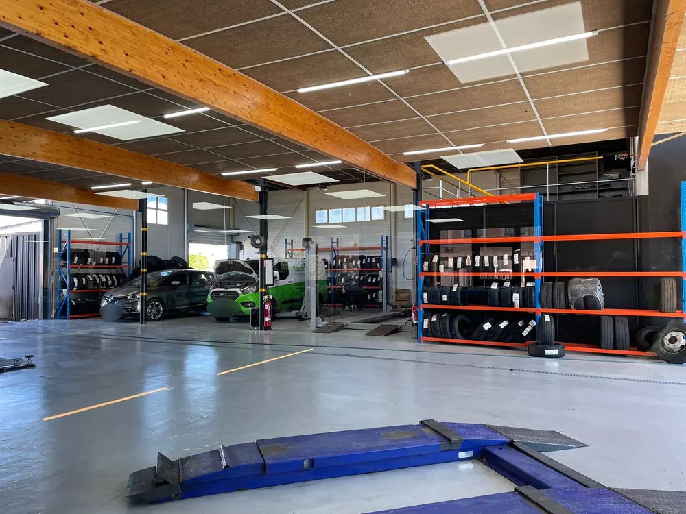 Atelier mécanique du garage Rapide Car Center à Aubagne avec ponts élévateurs et stock de pneus